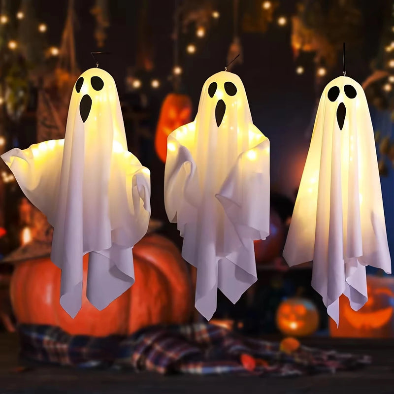Bo the hanging ghost light glowing warm white above a pumpkin