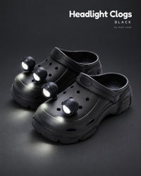 Black platform clogs with four black LED headlights glowing on the toes