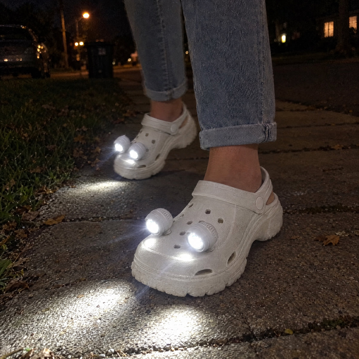 White platform clogs with four LED headlights lighting up a sidewalk at night