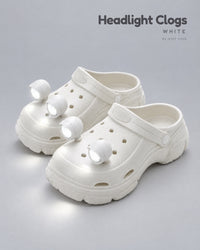 White platform clogs with four white LED headlights glowing on the toes